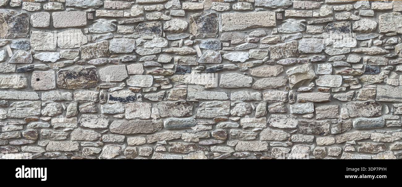 Stone wall showing irregular blocks creating a textured architectural background Stock Photo
