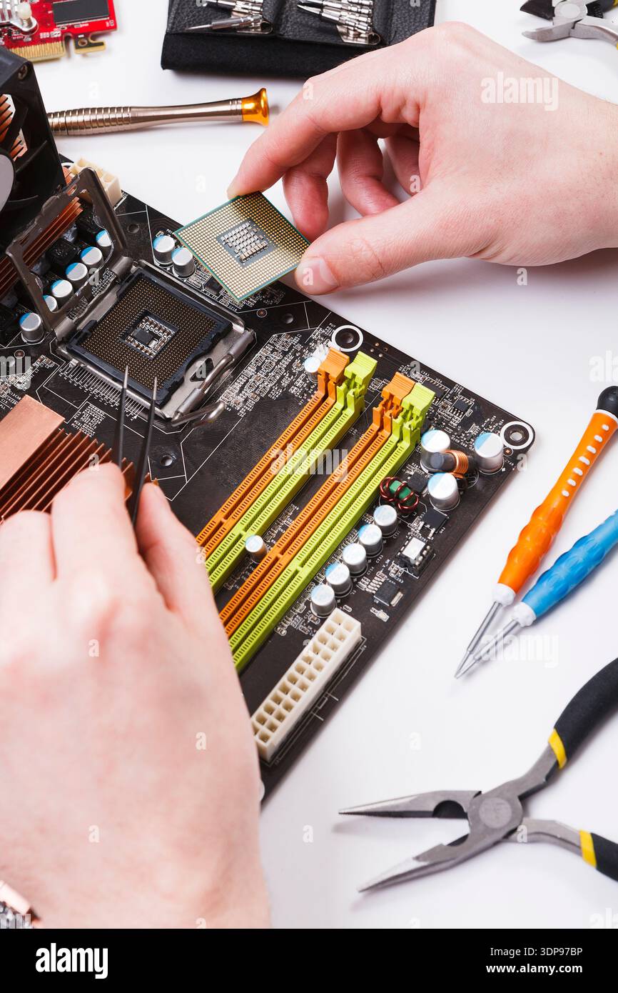 Technician plug in microprocessor to motherboard Stock Photo