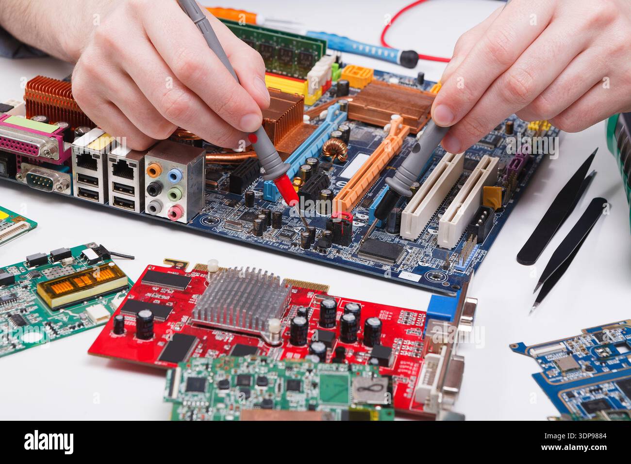Engineer checking motherboard with multimeter Stock Photo
