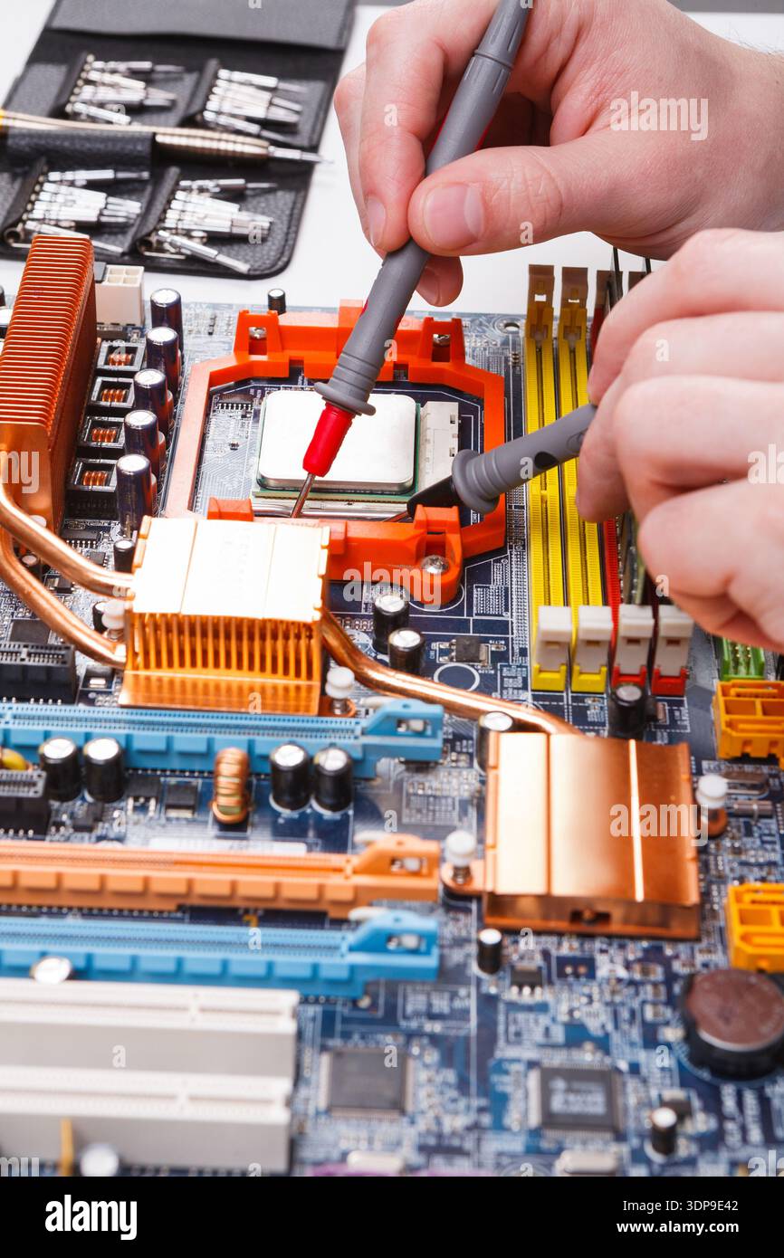 Computer Engineer Motherboard Engineer checking motherboard with multimeter Stock Photo - Alamy
