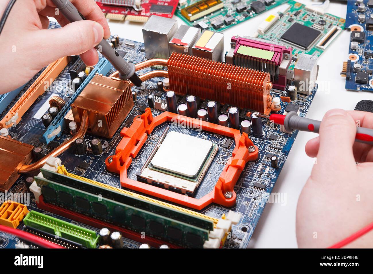Engineer checking motherboard with multimeter Stock Photo