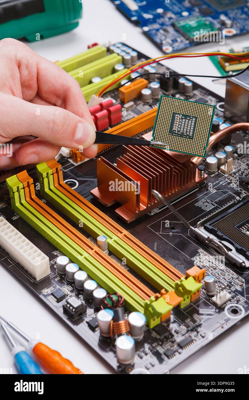 Technician plug in microprocessor to motherboard Stock Photo