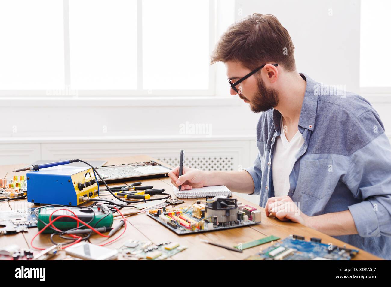 Someone Working on Computer Circuit Boards in a Bright Workshop During the Day Stock Photo