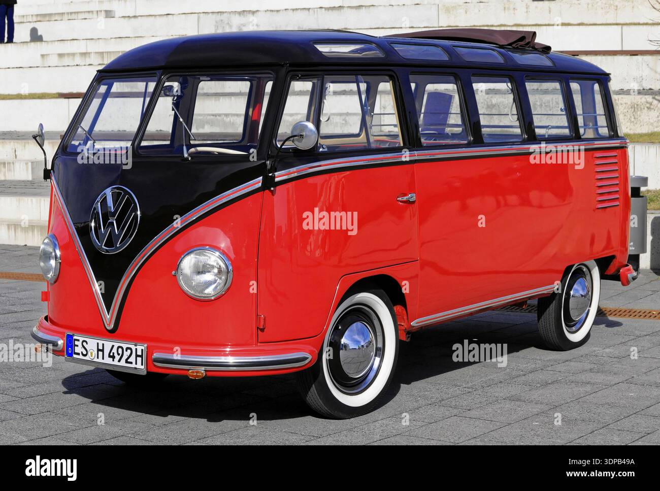 A red and black VW bus in the sunshine gives off a nostalgic