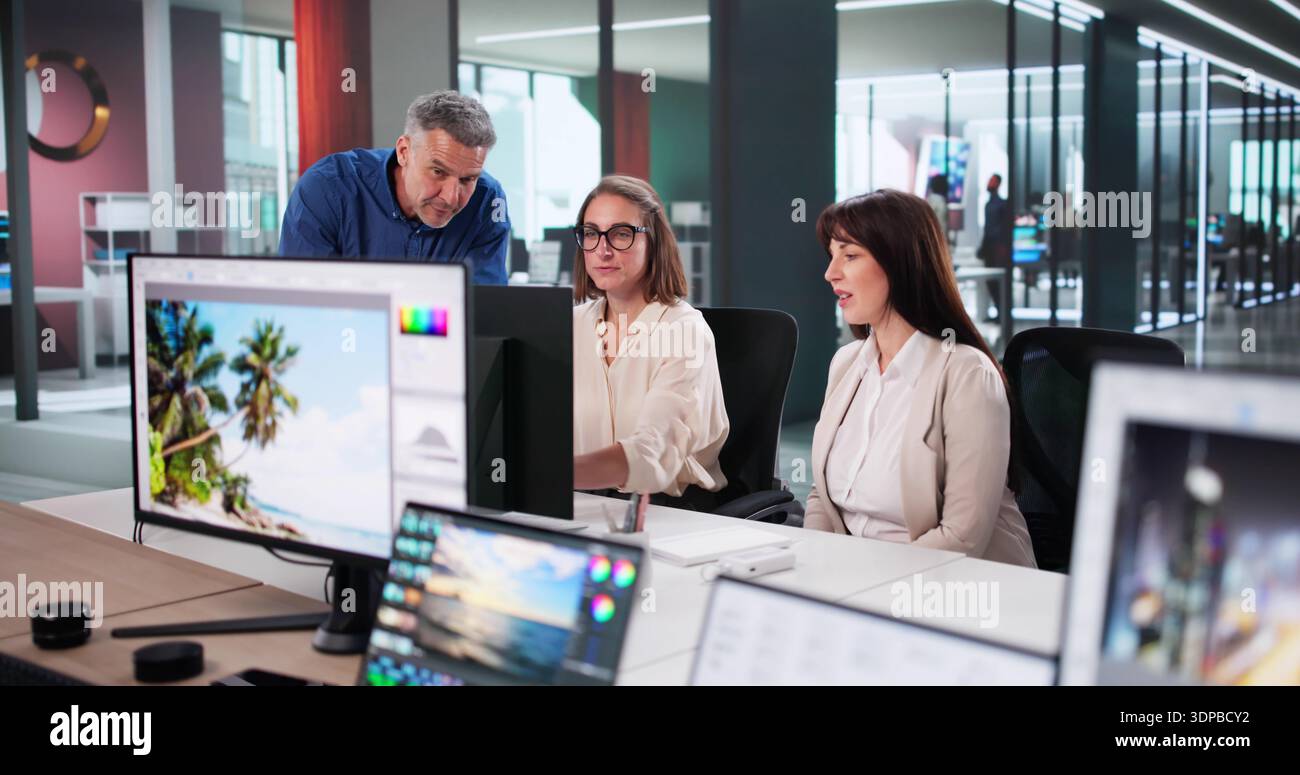 Creative Team Collaborates On Graphic Design Projects Using Desktop Computers Stock Photo