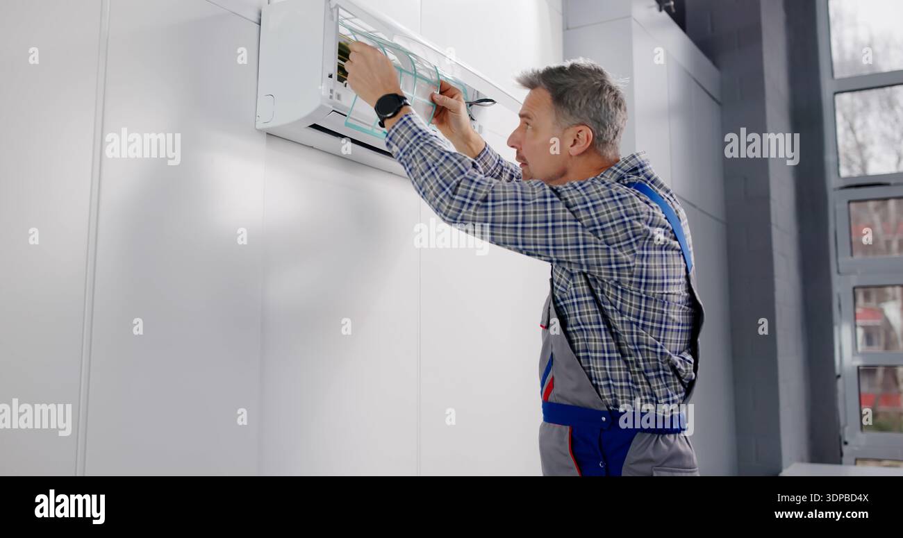 Professional HVAC Technician Performs Air Conditioner Cleaning And Filter Change. Stock Photo