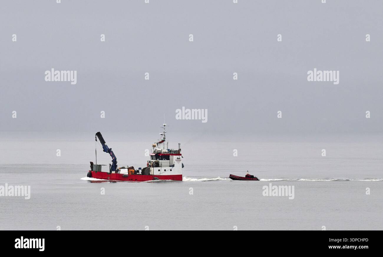 fischerboot sucht den weg durch den nebel Stock Photo