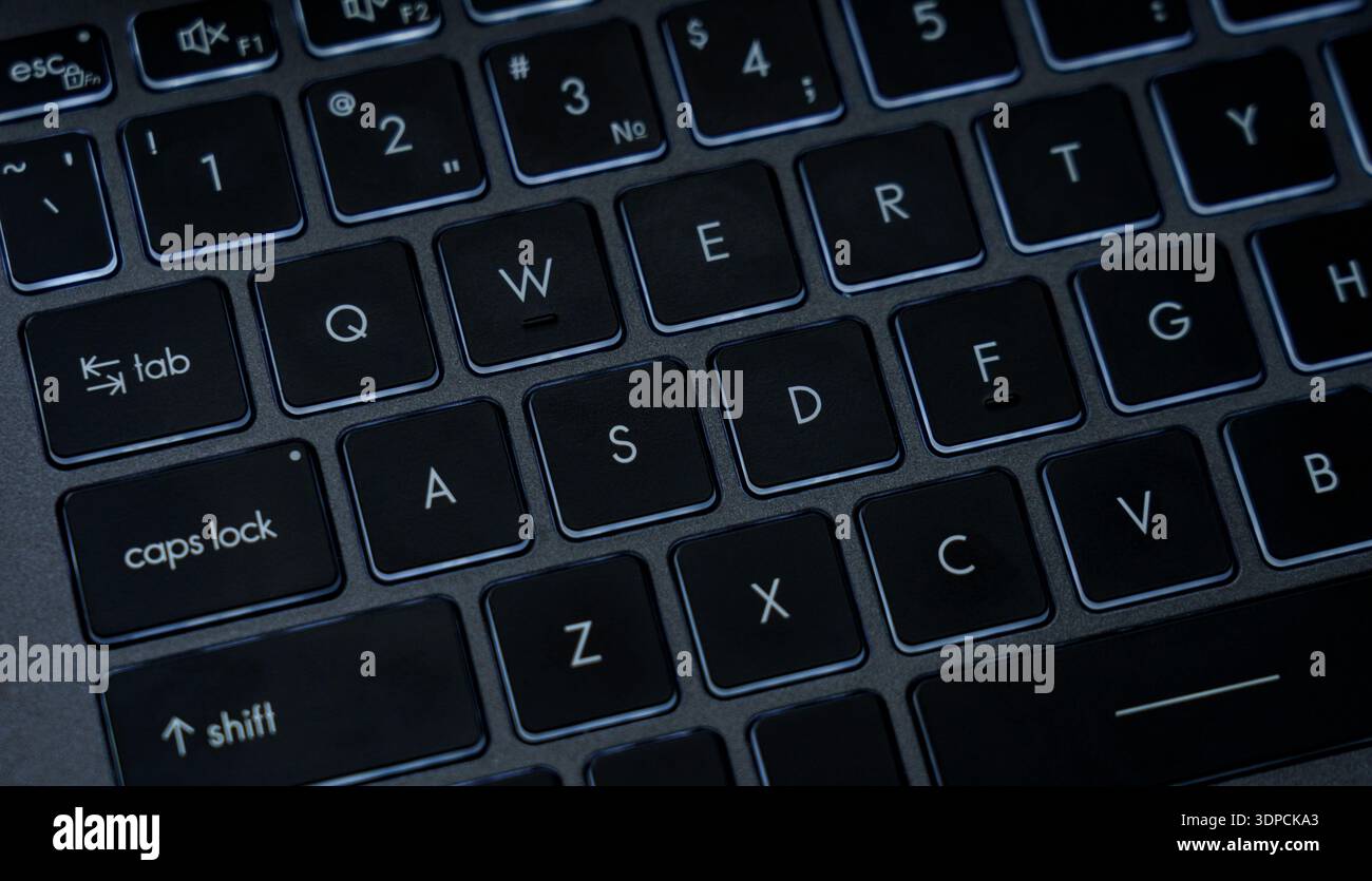 The picture shows a close view of a laptop keyboard in a home office ...