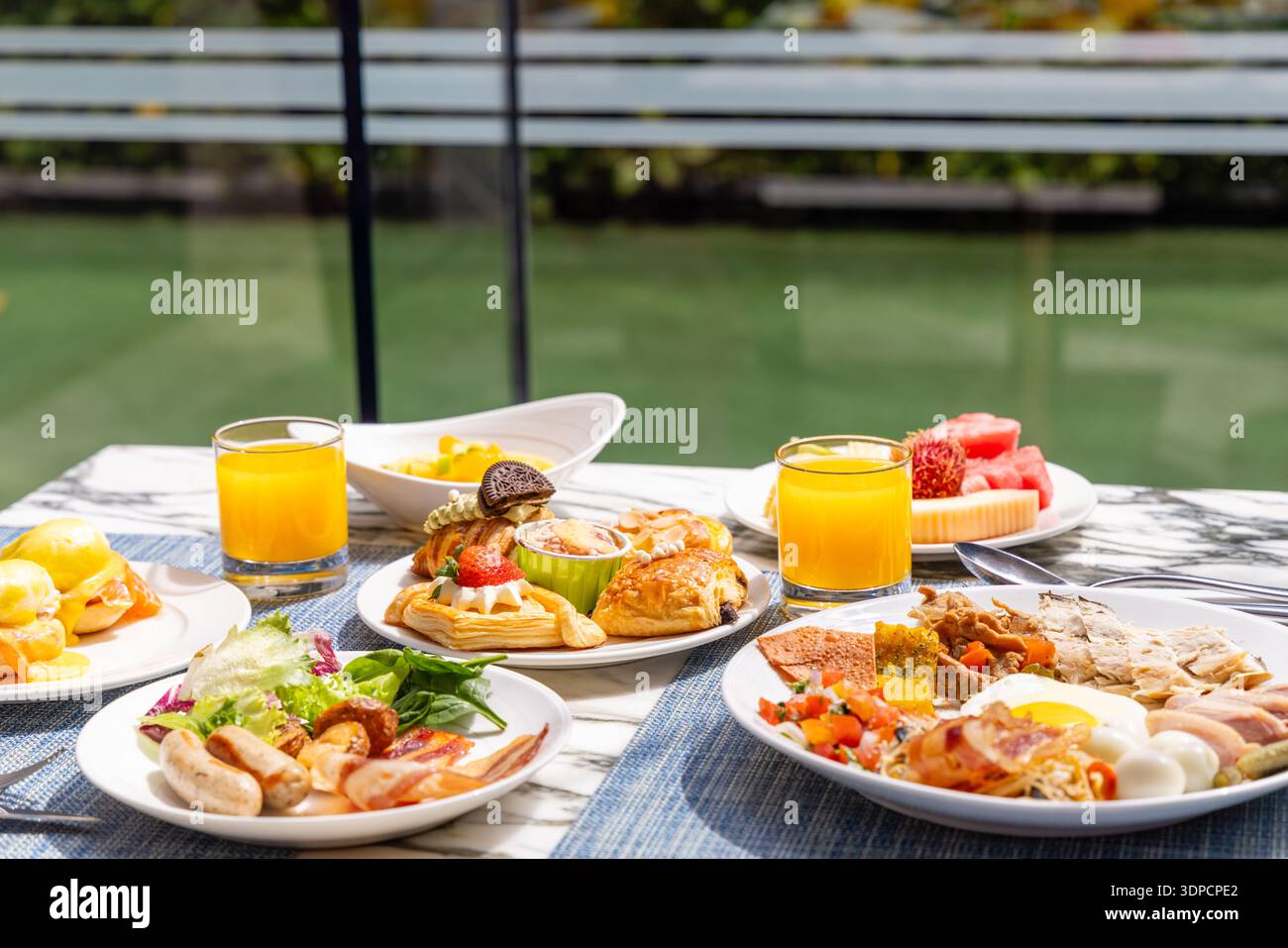 Luxurious breakfast spread on marble table by window includes pastries Stock Photo