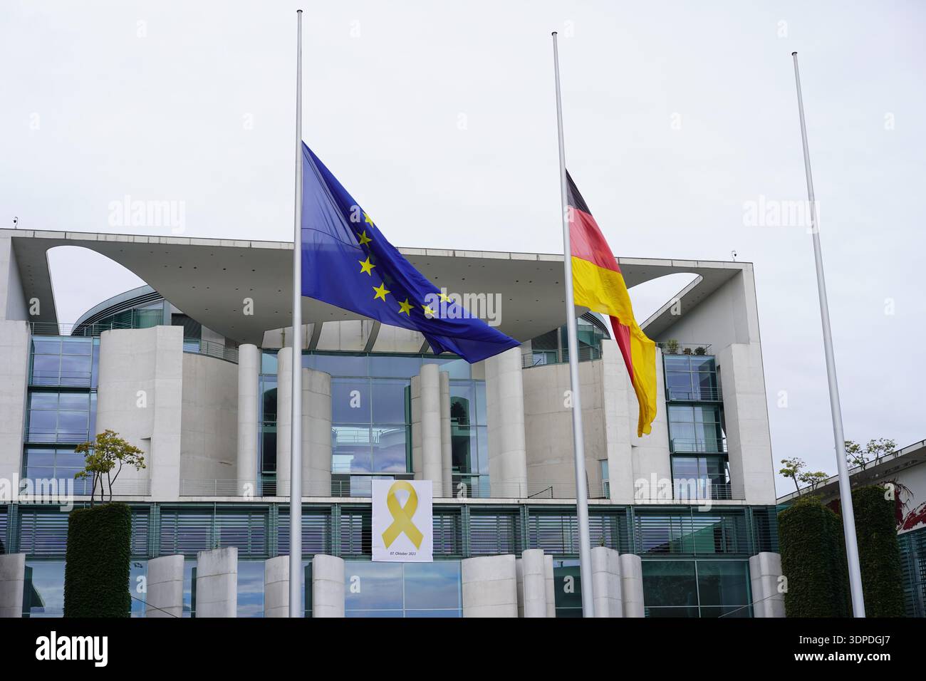 Berlin, Germany - October 7, 2024: The Federal Chancellery with flags at half-mast and yellow ribbon banner for the 1st anniversary of Oct 7 attacks. Stock Photo