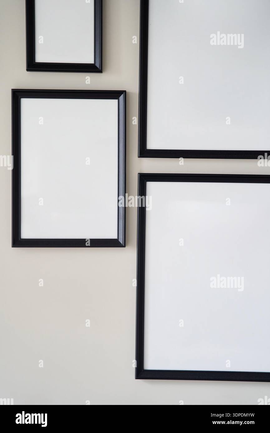 Different size framed photos hanging on the gray wall. Mockup. Stock Photo
