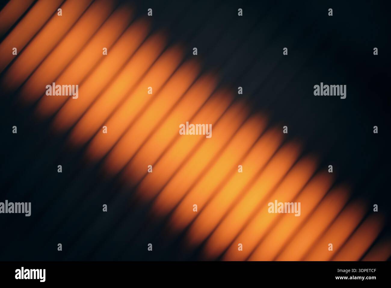 Orange light creating blurry diagonal line pattern on dark background Stock Photo