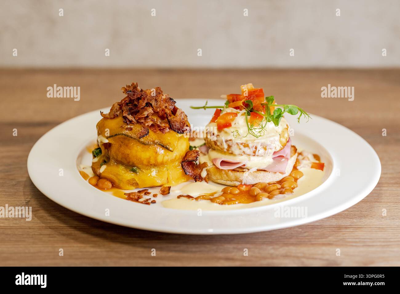 Gourmet breakfast plates with eggs benedict and savory pumpkin stack Stock Photo
