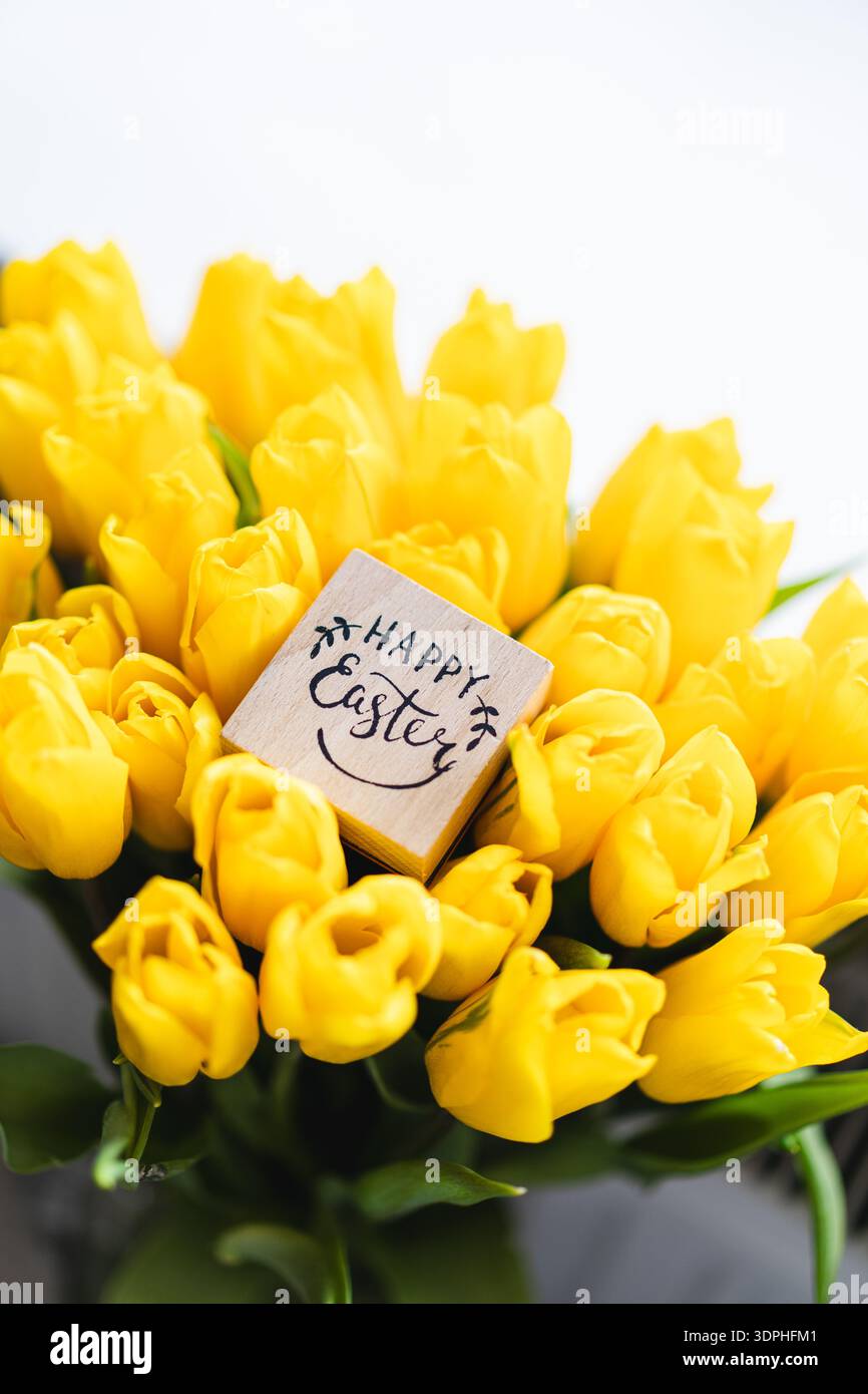 Spring festive composition with yellow tulips and decorative eggs Stock Photo