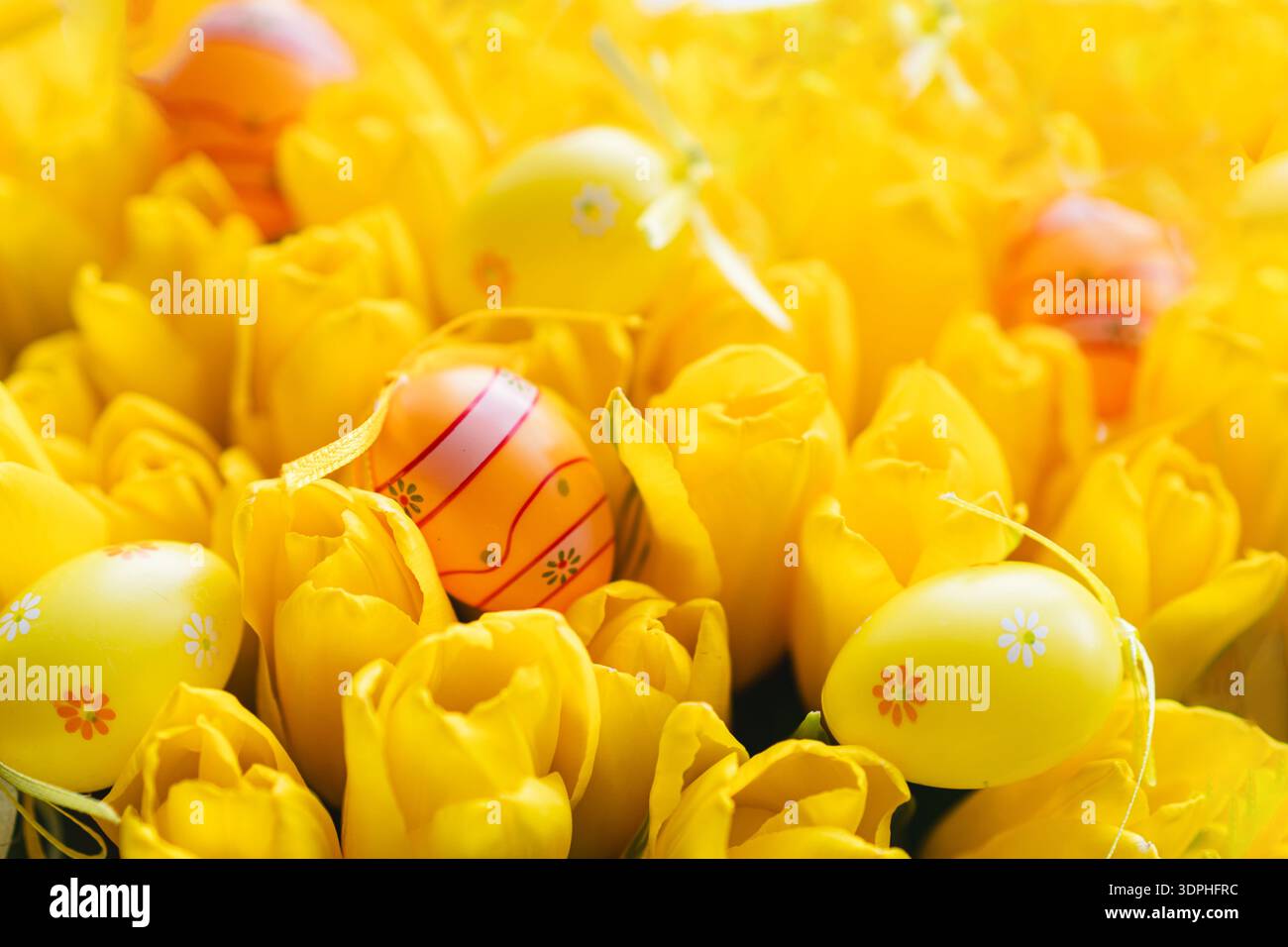 Spring festive composition with yellow tulips and decorative eggs Stock Photo