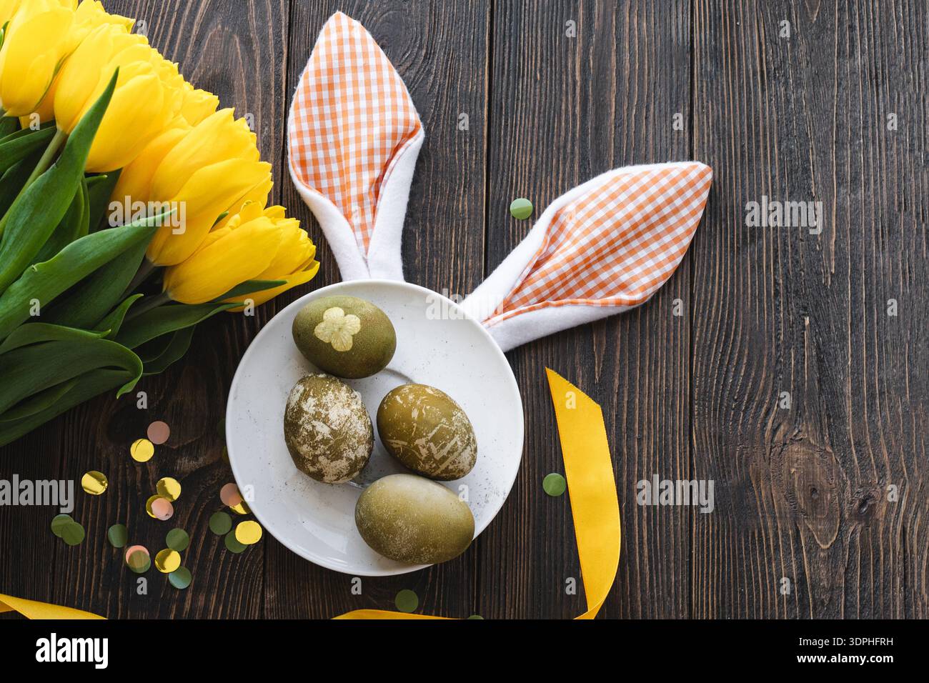 Easter flat lay composition with yellow tulips, natural dyed Easter eggs Stock Photo