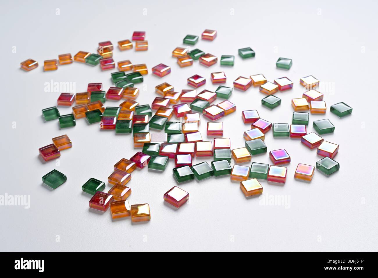a background made with some colored glass tiles scattered on a white surface Stock Photo