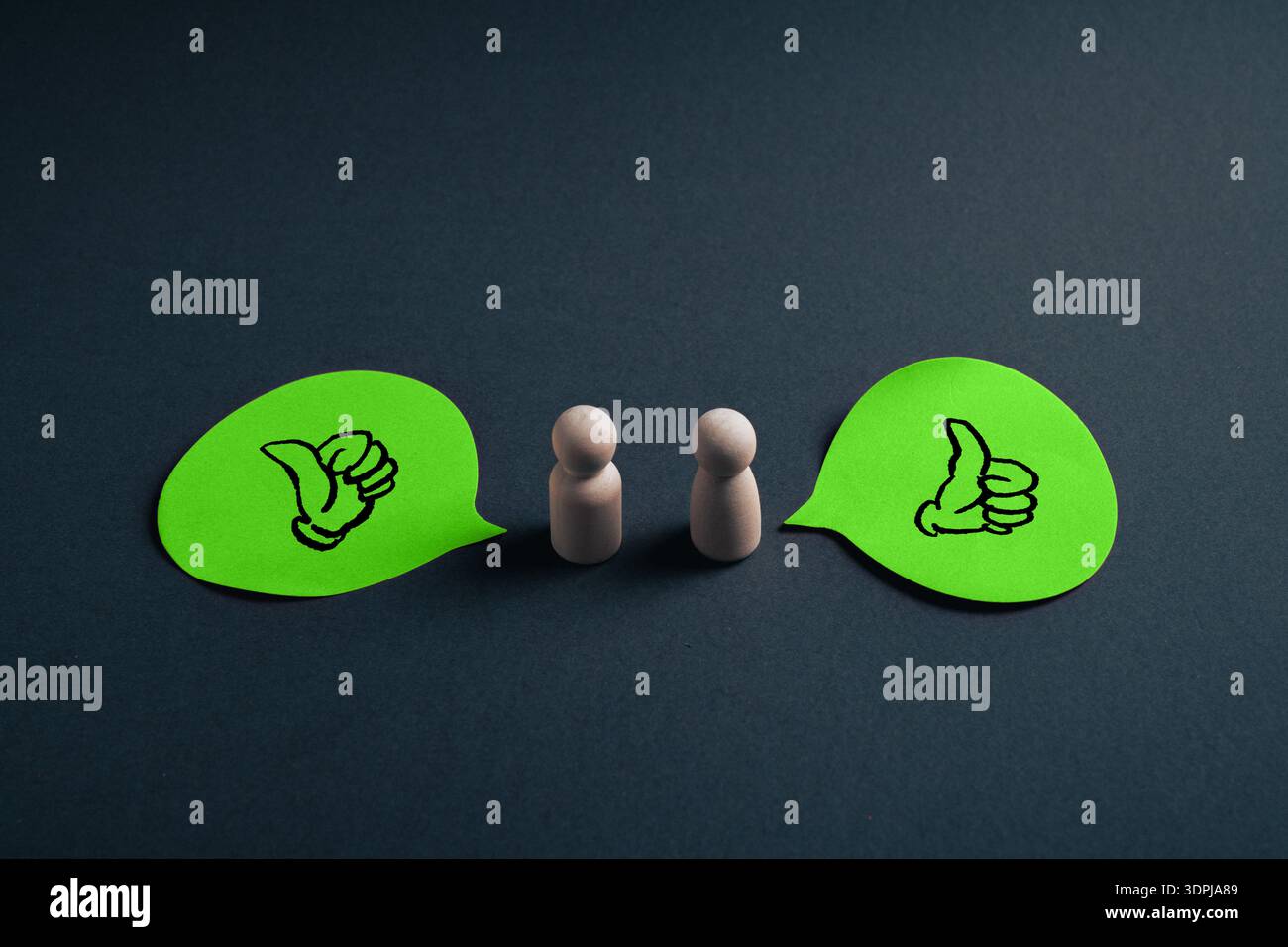 Conceptual image of two wooden figures facing each other with green ...