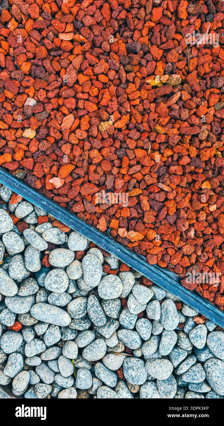 Red Volcanic Lava Rocks and White Garden Pebbles Separated by Edging ...