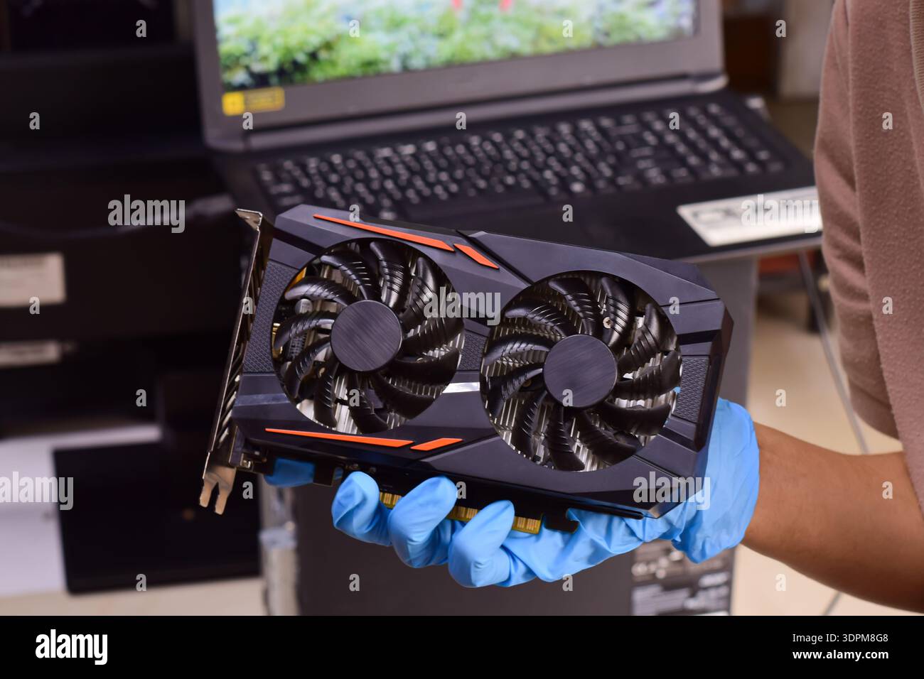 The technician is holding a computer graphics card and other computer components. Stock Photo