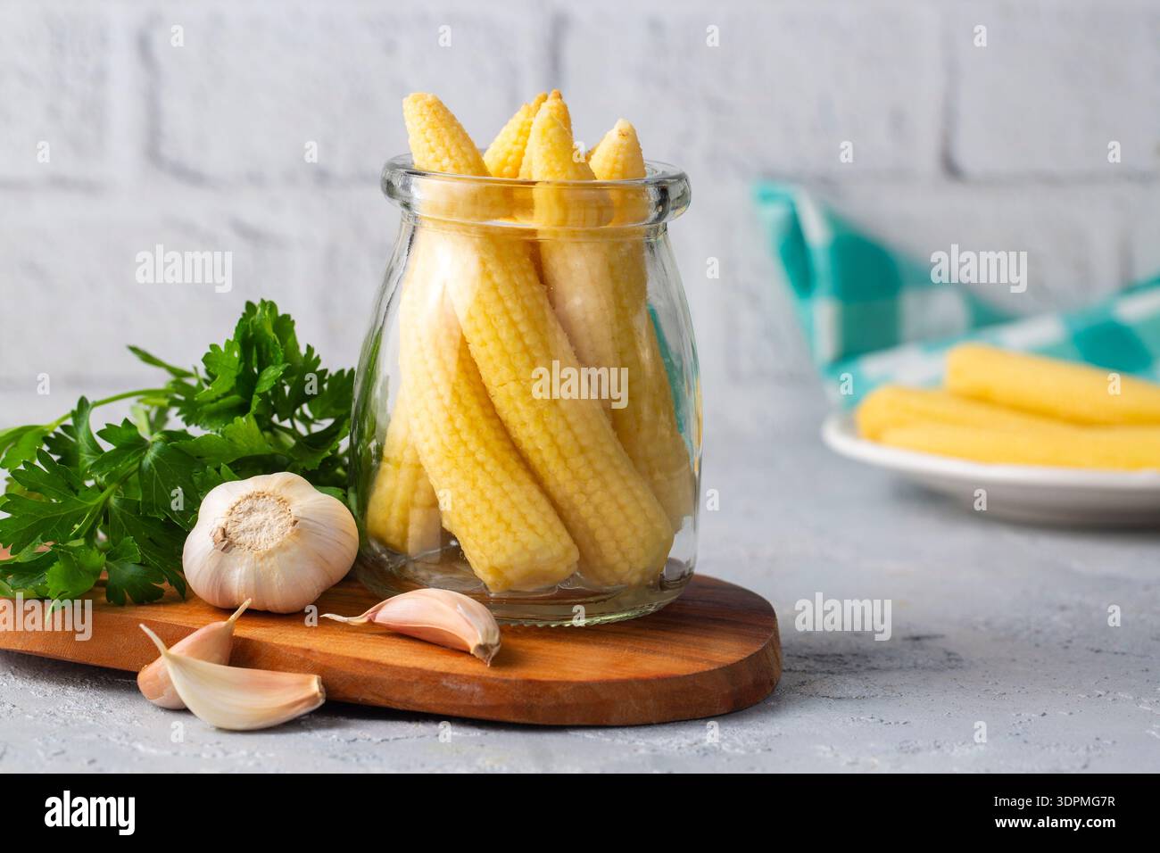 Pickled young baby corn cobs in jar Stock Photo