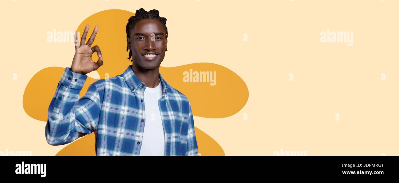 Young Man Gives a Hand Gesture While Smiling in a Simple Collage Setting Stock Photo