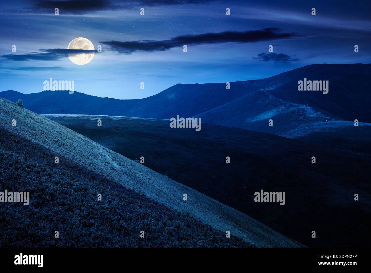 scenic mountain landscape in summer at night. beautiful travel background with rolling hills. lush green grassy hillside in full moon dappled light. n Stock Photo
