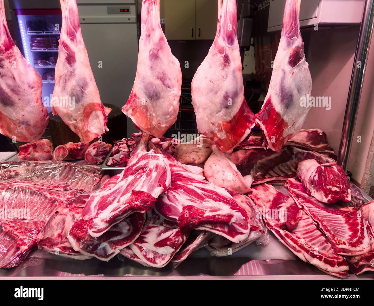 Assorted cuts of fresh raw lamb meat, including hanging legs and ribs ...