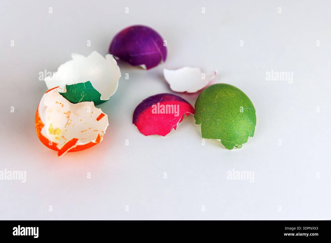 Colorful cracked easter egg shells on white background with copy space. Soft focus Stock Photo