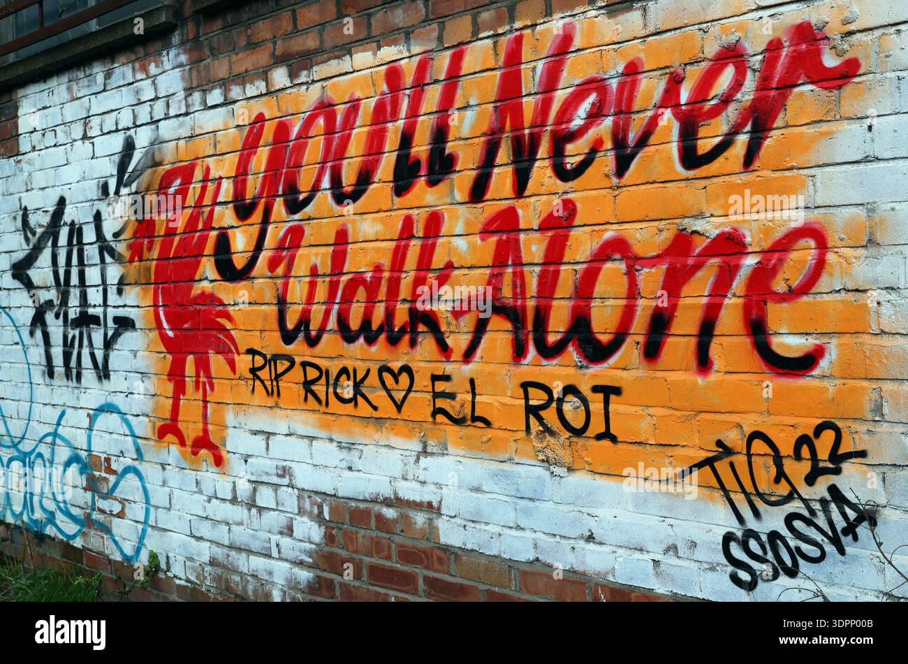 Liverpool FC themed graffiti reading “You Will Never Walk Alone” and “Good will never walk alone” on a brick wall in Liverpool, England. Stock Photo