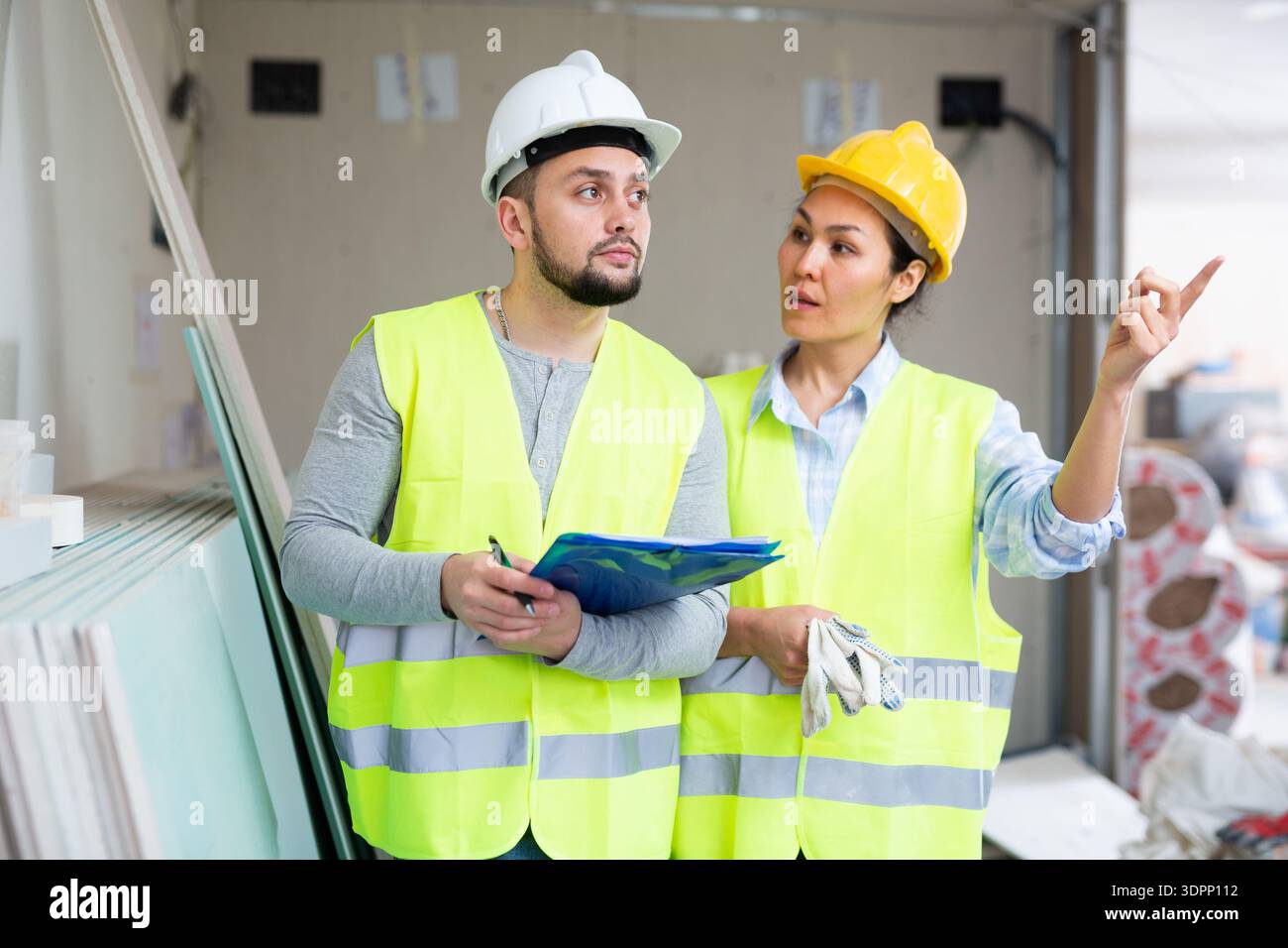 Woman and man repairers talking about documentation Stock Photo