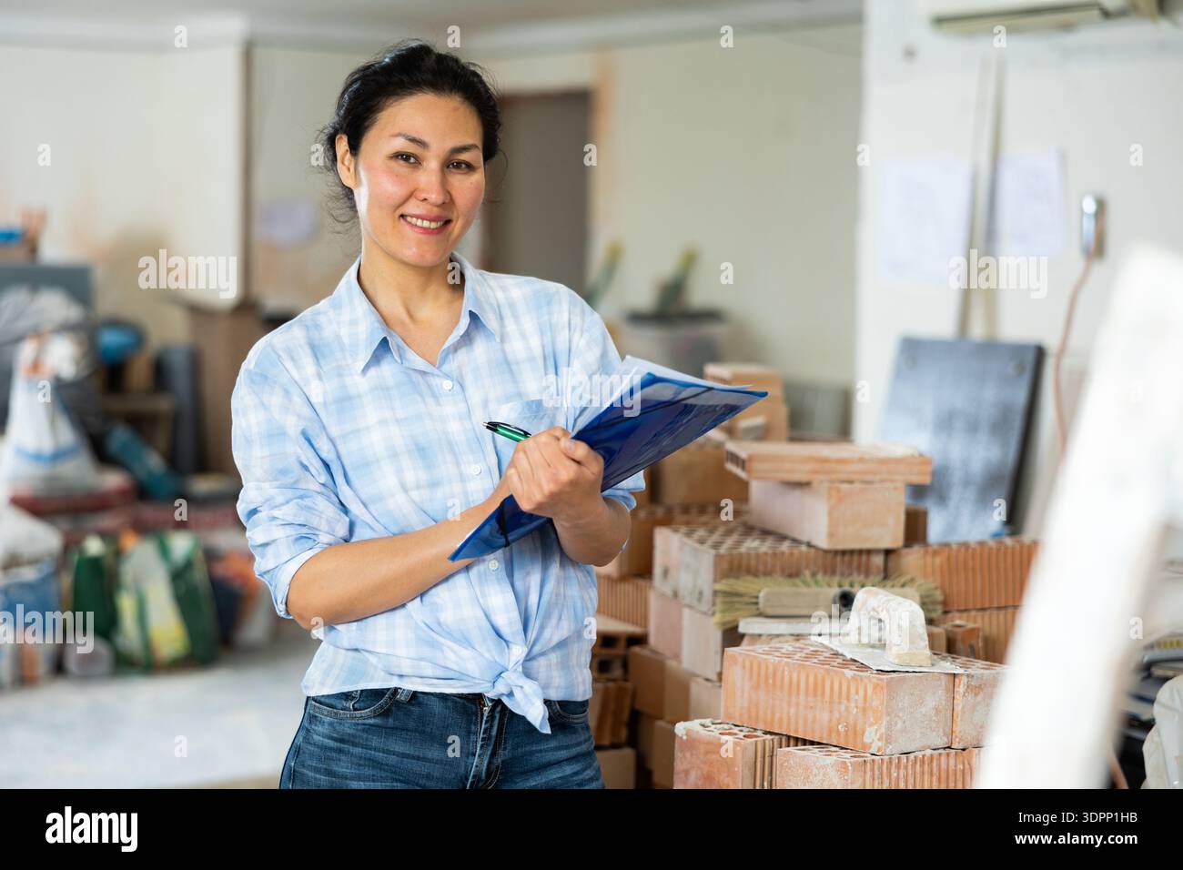 Woman making notes at renovating house Stock Photo