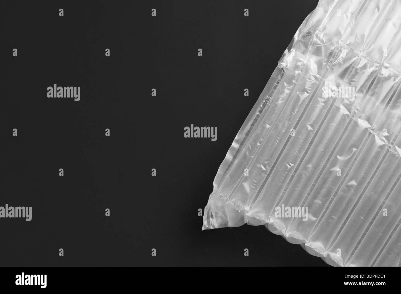 Transparent air buffer packaging on black background, top view. Space for text Stock Photo