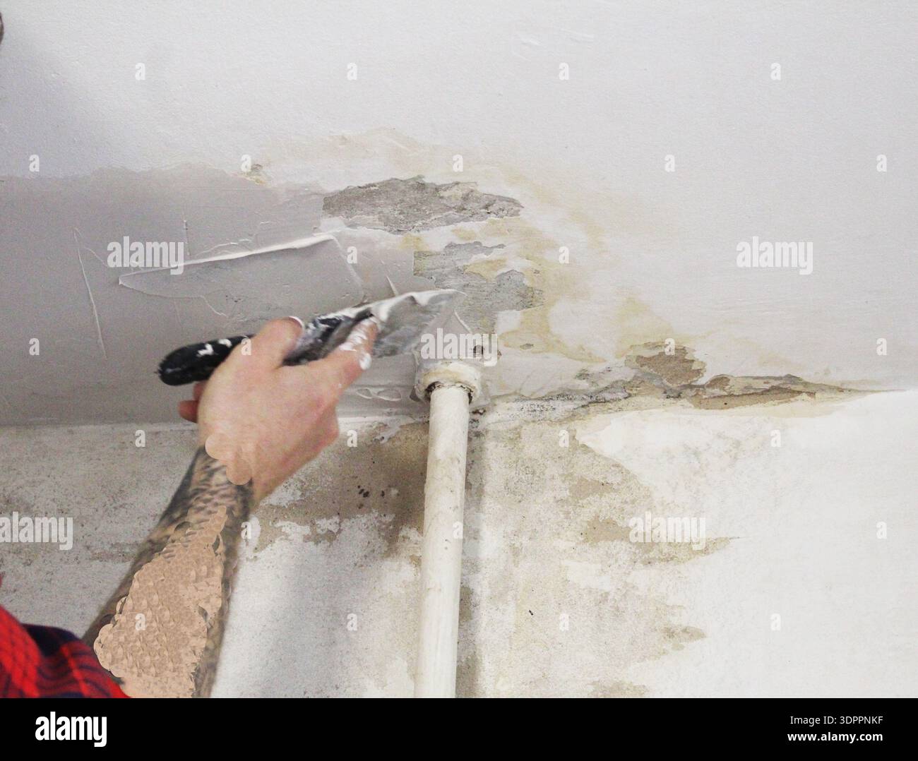 Master man applying putty plaster to the ceiling close-up. Stock Photo