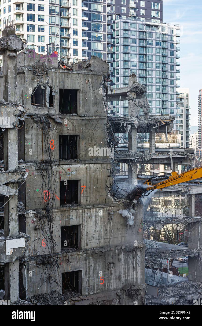 Excavator with hydraulic attachment is working on building demolition ...