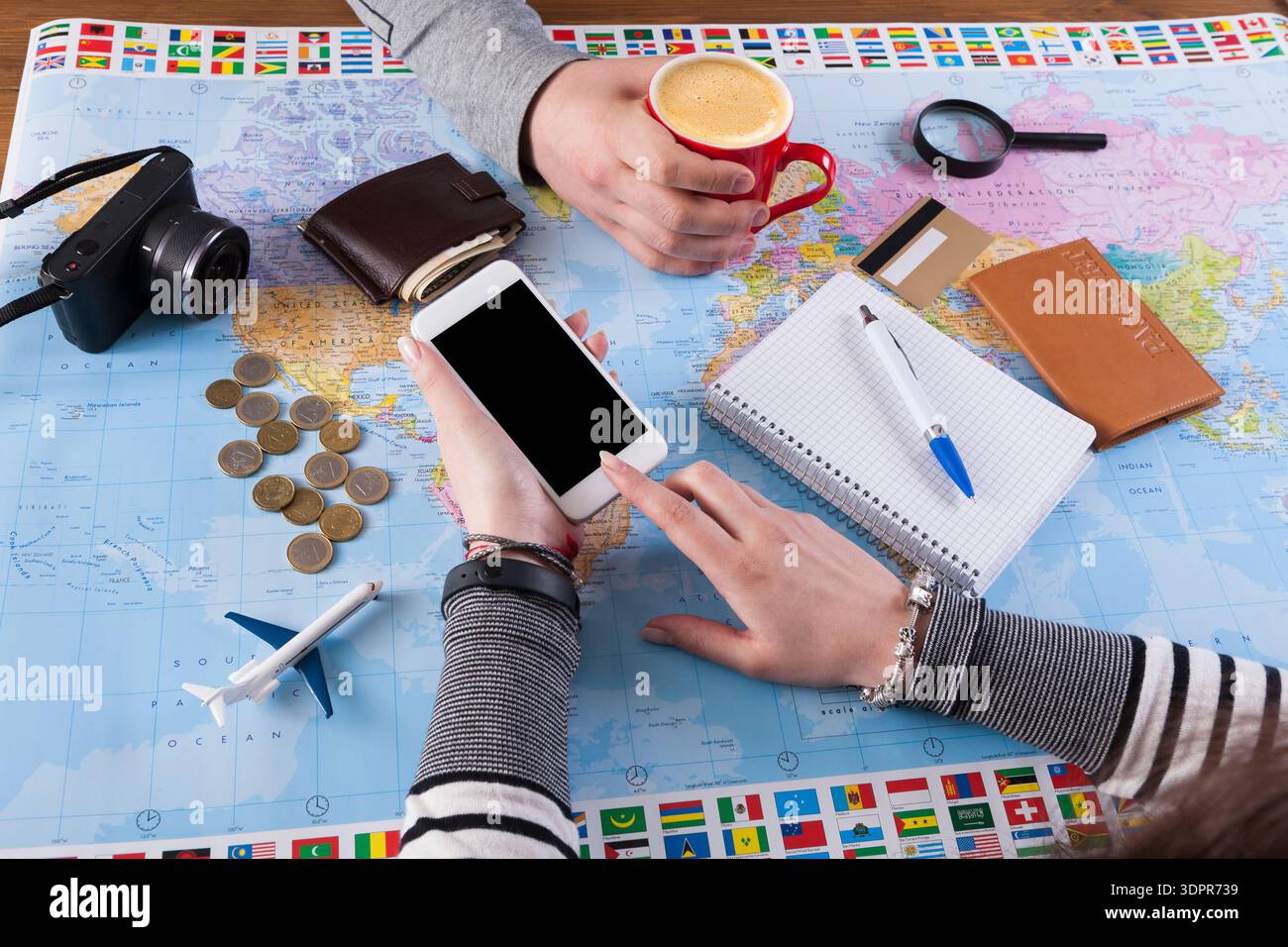 Planning a Trip With Coffee, Maps, and a Smartphone at a Table Stock Photo