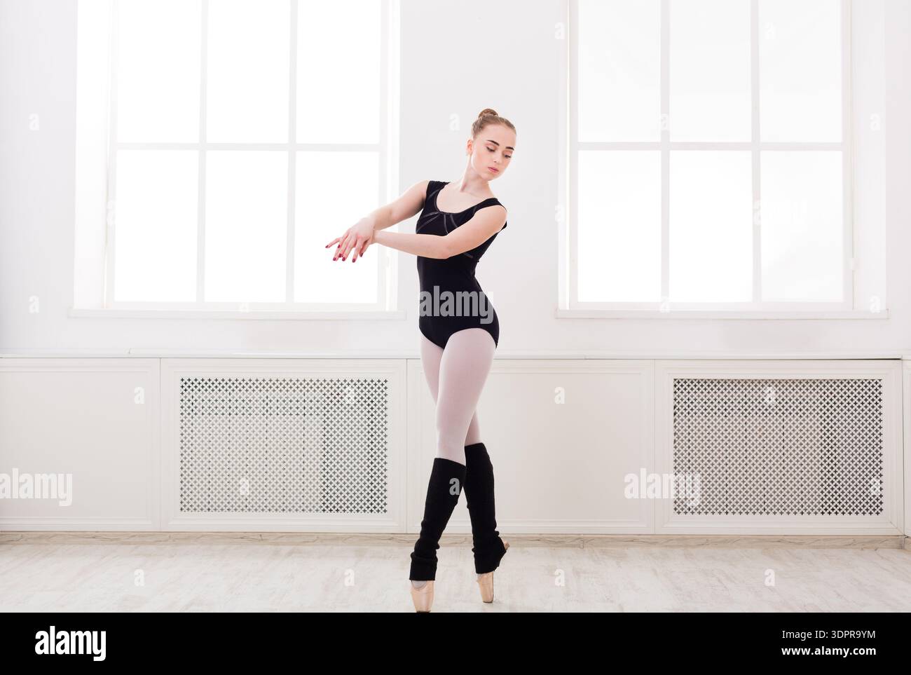 Ballet Dancer Performs in Studio With Large Windows and Natural Light During Daytime Stock Photo