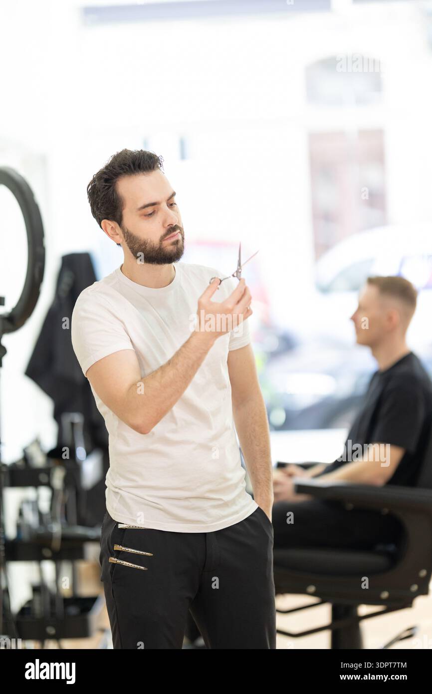 Barber preparing scissors for client grooming service Stock Photo