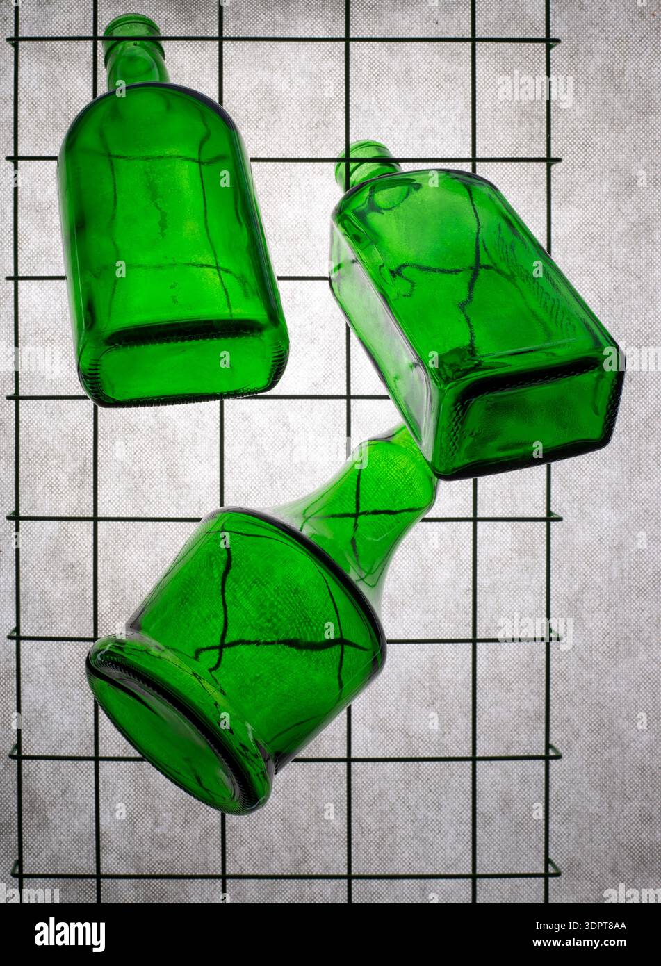 Three green empty bottles on a gray background Stock Photo
