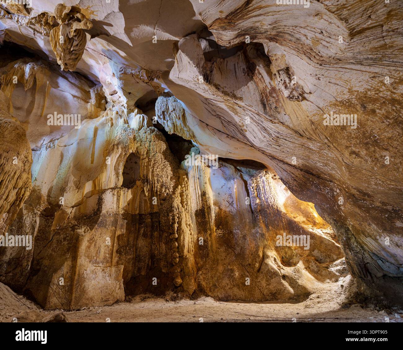 Interior view of a limestone cave featuring flowstone walls, layered ...