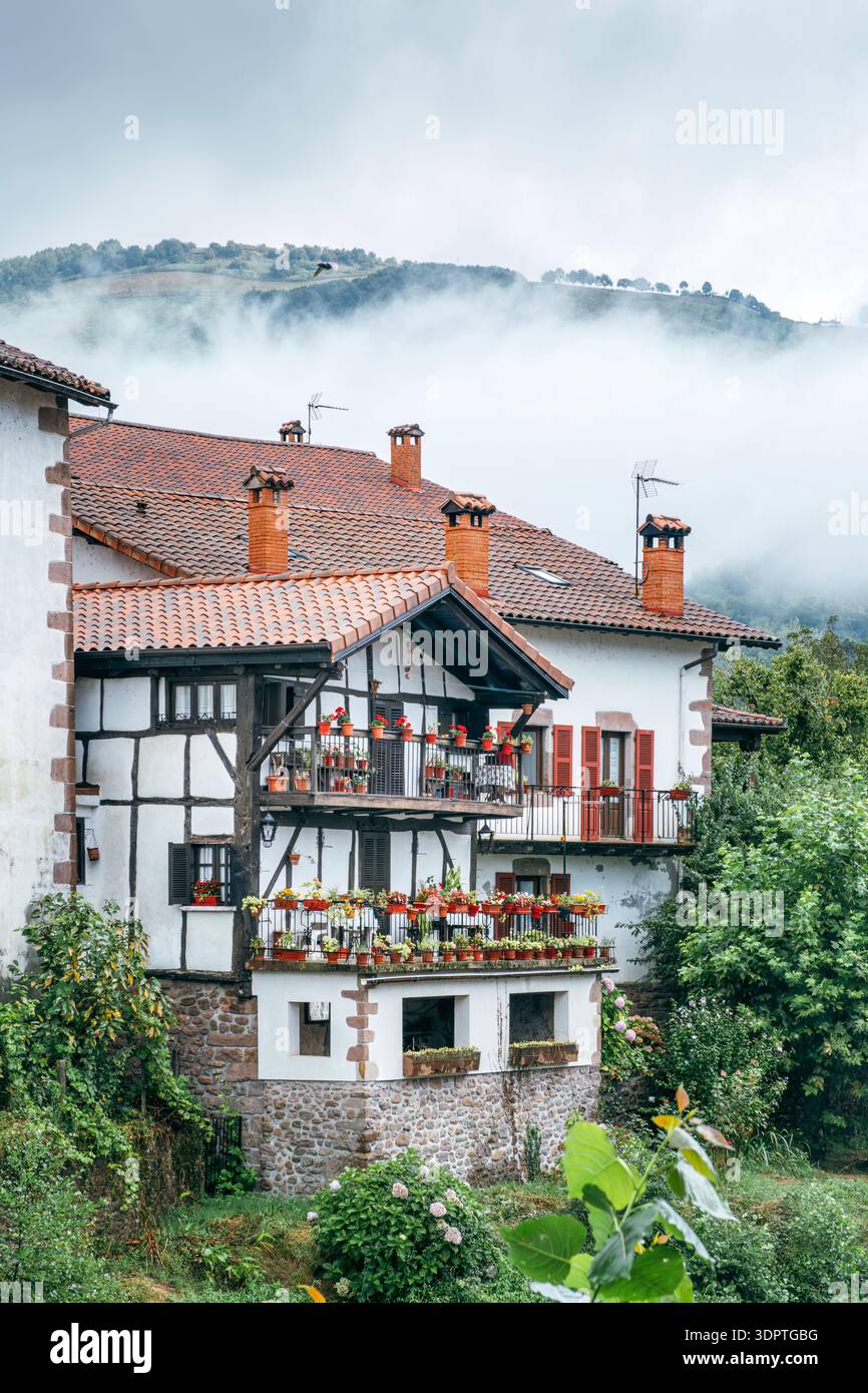 Traditional Basque House with Flower Balconies in Elizondo, Foggy Mountains, Baztan Valley, Spain Stock Photo