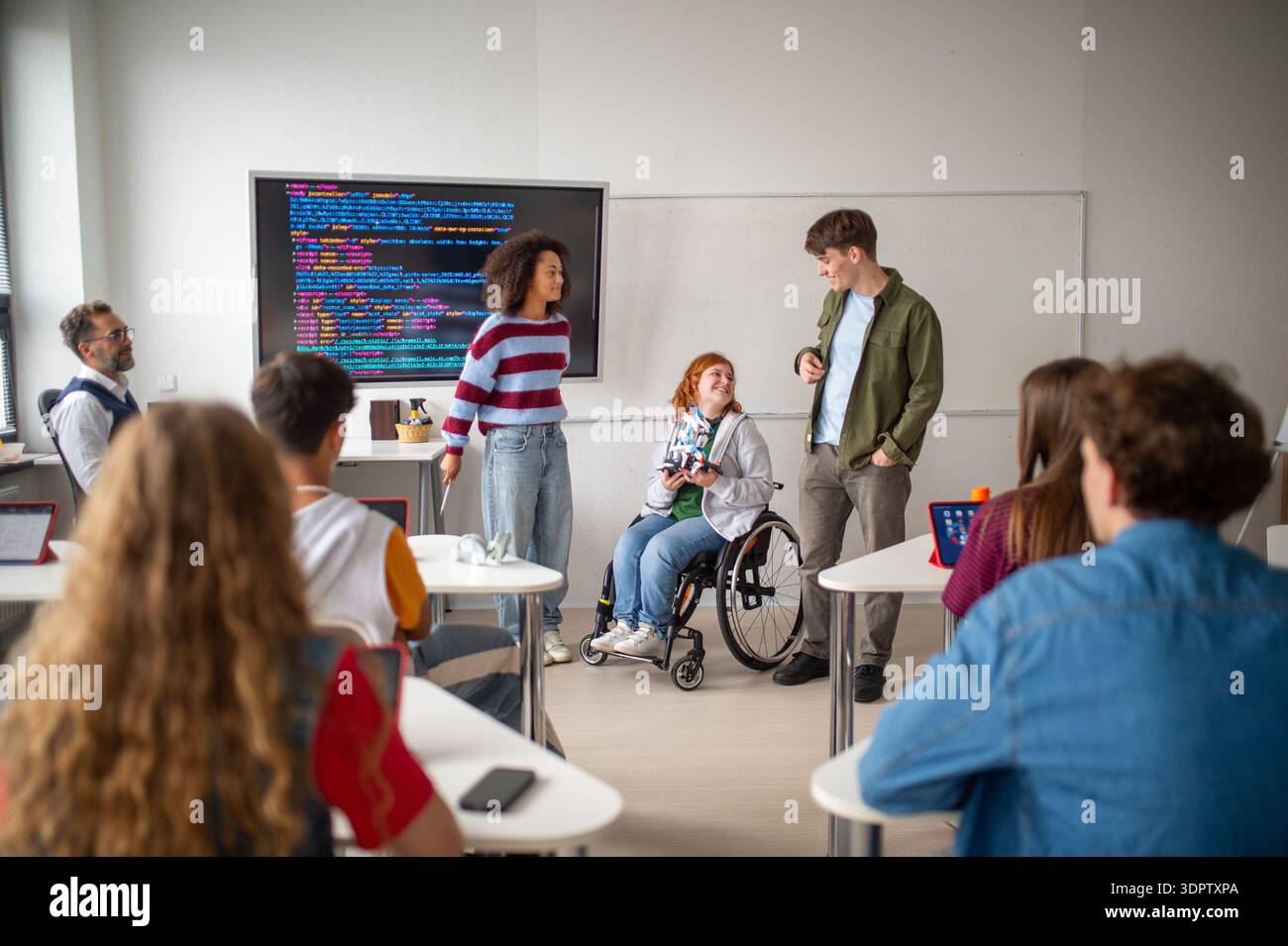 Inclusive student team presenting technology project in class. Stock Photo