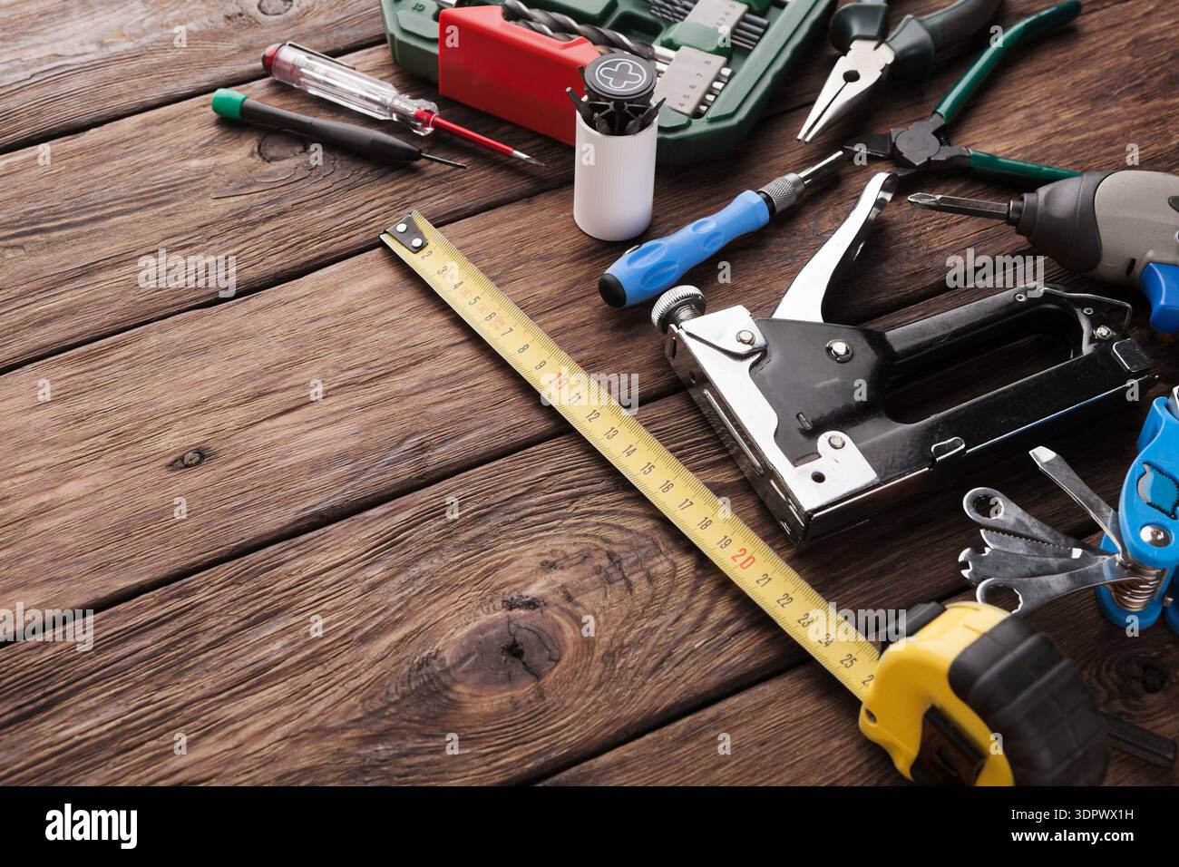 Tools Spread on Wooden Surface for Various Tasks in Workshop Setting During Daytime Stock Photo
