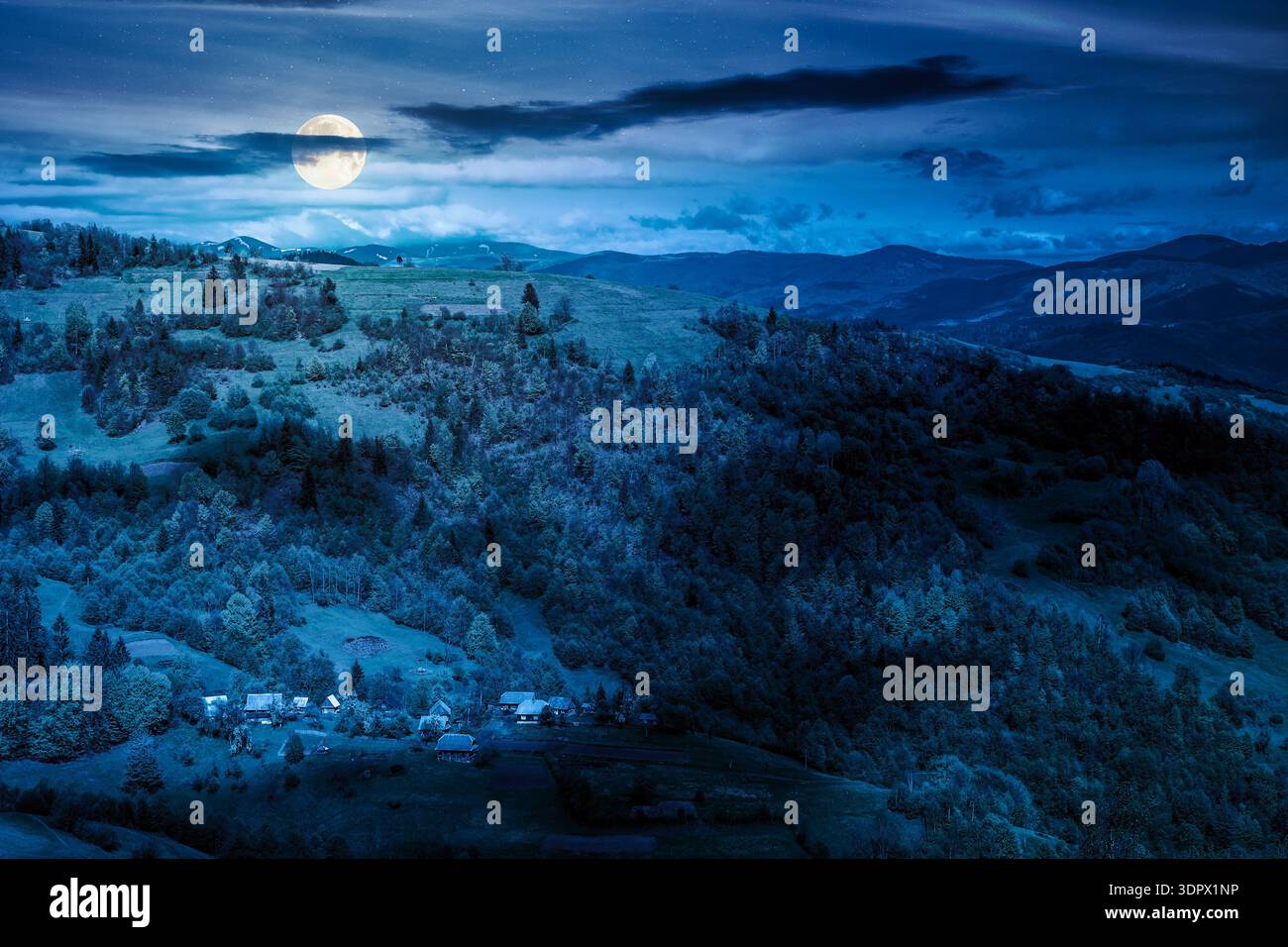 beautiful rural area in mountain landscape at night. village on a steep green hill in full moon light during spring. alpine countryside scenery in dap Stock Photo