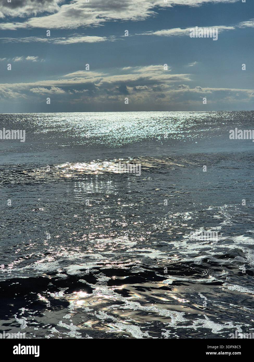 Sunlight reflecting on the sparkling sea waves. Stock Photo