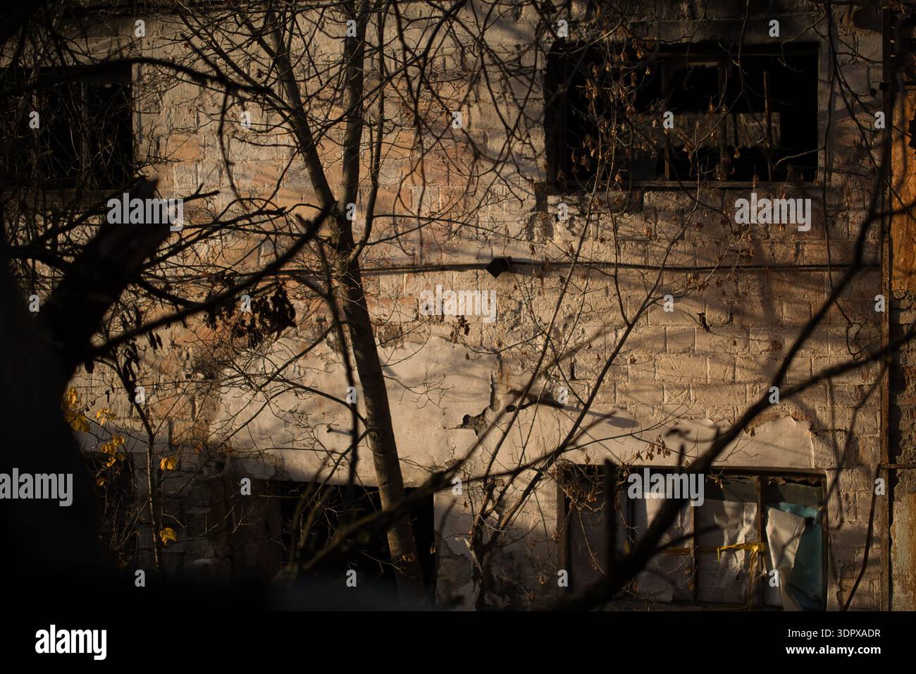 Abandoned House Wall with Broken Windows at Sunset Stock Photo