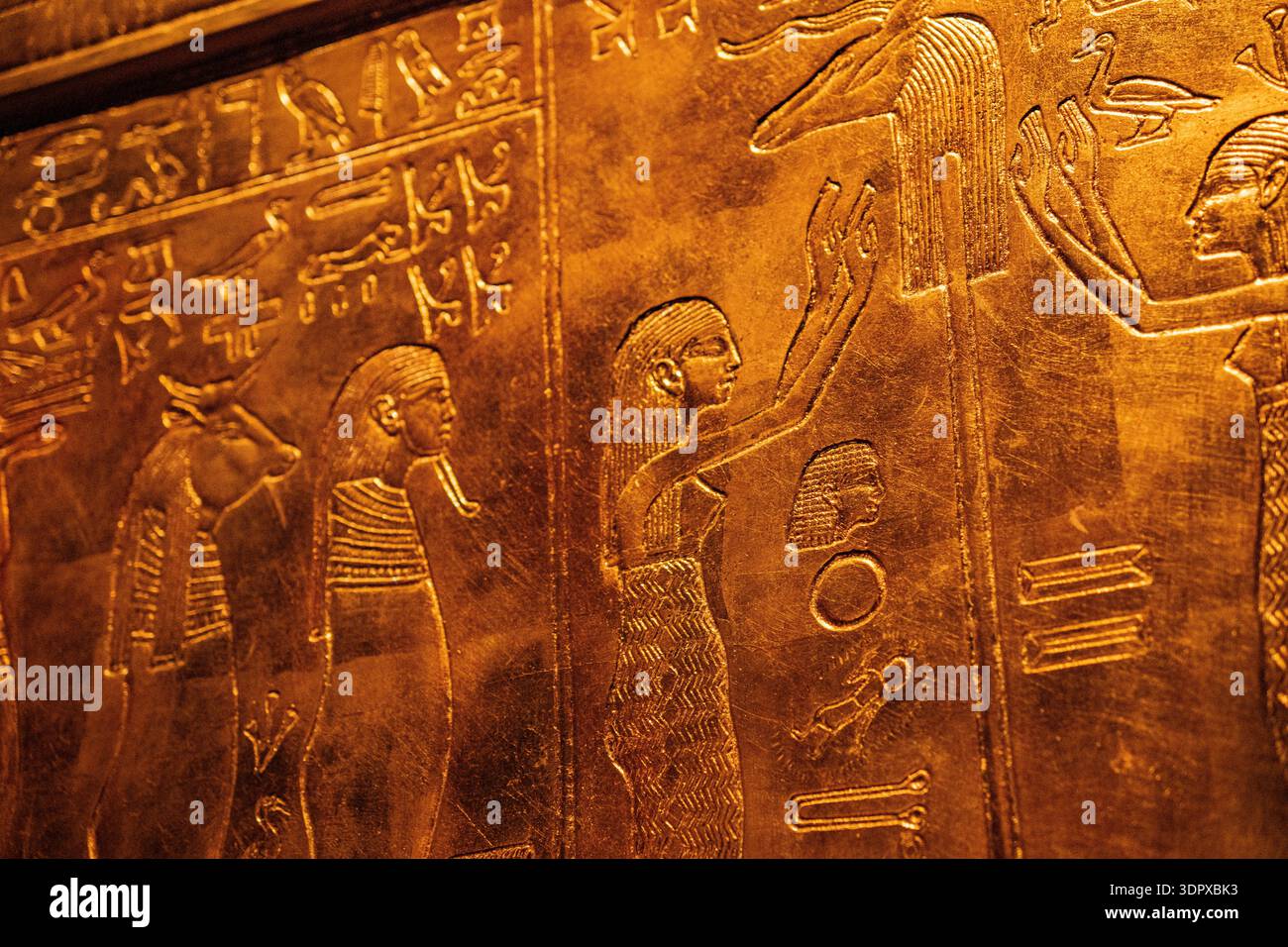 Golden ancient Egyptian wall with carved hieroglyphs and symbolic ...
