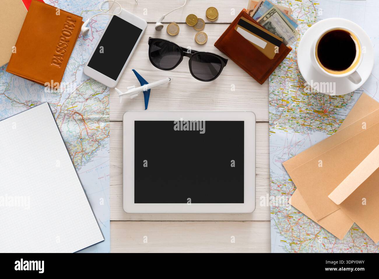 Travel Planning Setup With Map, Devices, and Essentials Prepared on the Table Stock Photo