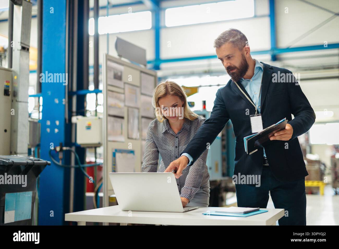 Industrial team analyzing data in high tech manufacturing plant. Stock Photo