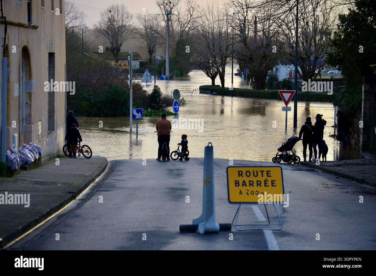 People look at a flooded street in Cadillac-sur-Garonne as severe ...